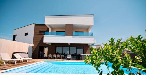 a house with a swimming pool in front of a house at Villa Estate in Novalja