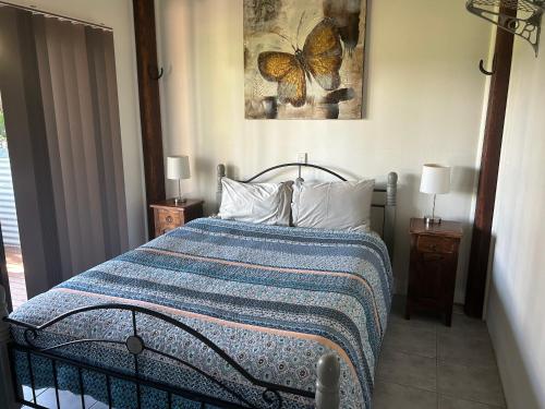 a bedroom with a bed with a blue and white blanket at Waterview Cottage in Baffle Creek