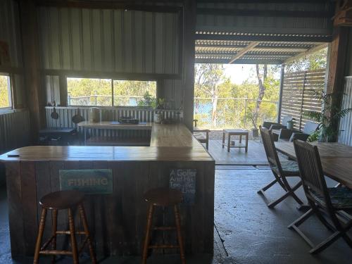 a bar in a room with chairs and tables at Waterview Cottage in Baffle Creek