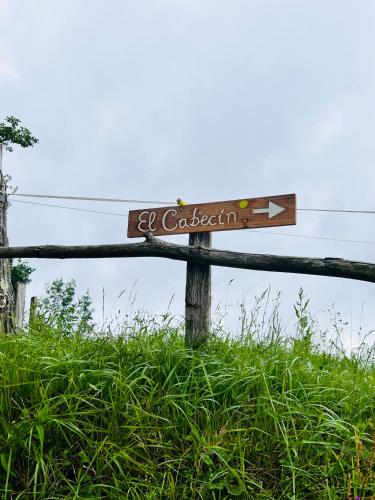 a wooden sign on a fence in the grass at La Casina del Cabecin en Parque Natural de Redes in Caso