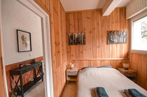 - une chambre avec des murs lambrissés et un lit dans l'établissement Appartement phare, à Soulac-sur-Mer
