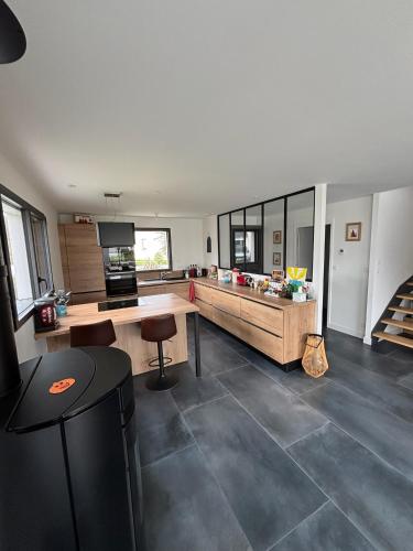 une grande cuisine avec une table et un comptoir dans l'établissement A 8 mns des plages et du golf ! Maison moderne avec jardin et grande terrasse, à Saint-Gildas-de-Rhuys