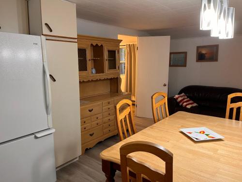 a kitchen and dining room with a table and a refrigerator at Camping Chalets Lac St-Augustin in Quebec City