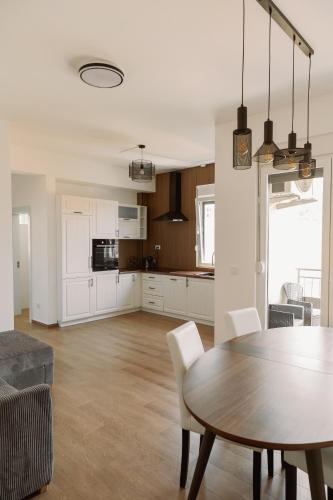 a kitchen and living room with a dining room table and a kitchen at Big Family apartment - 3BR in Budva