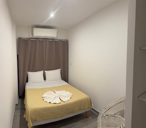 - une petite chambre avec un lit fleuri dans l'établissement Le NINI HOME, à La Grande Motte