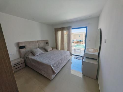 a bedroom with a bed and a view of a pool at Dar Ayla à DJERBA houmt souk in Houmt Souk
