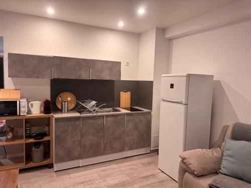 une cuisine avec un réfrigérateur blanc dans une pièce dans l'établissement Le NINI HOME, à La Grande Motte