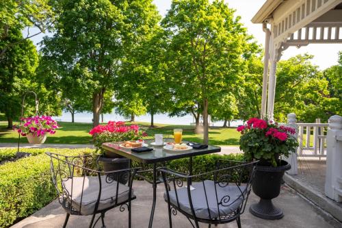 a table and chairs on a patio with flowers at The Old Bank House in Niagara on the Lake