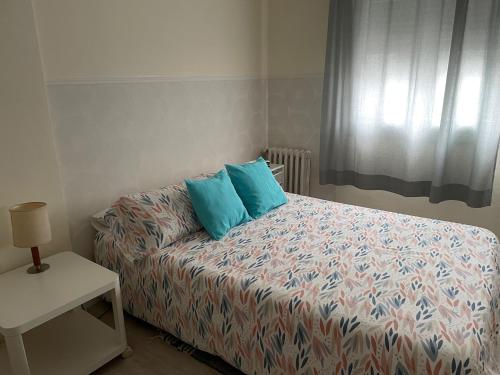 een slaapkamer met een bed met blauwe kussens erop bij Céntrico Hospedaje en Vigo in Vigo