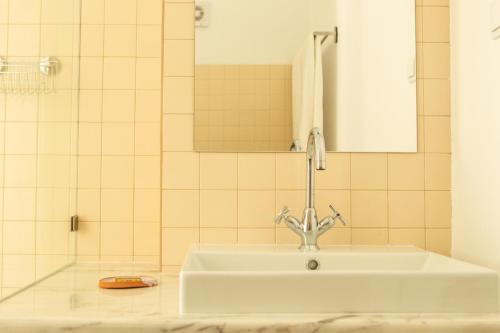 un lavabo blanc dans une salle de bain avec un miroir dans l'établissement Vida na Vila, à Vila Nova de Milfontes