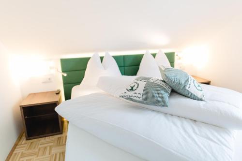 a white bed with blue and white pillows on it at Villa zur Schmied'n in Ehrenhausen