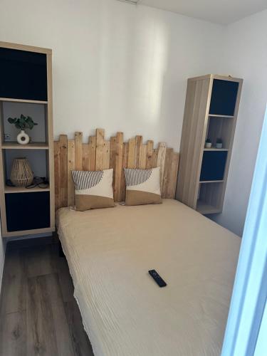- un lit avec une tête de lit en bois dans l'établissement Appartement dans résidence privée avec piscine proche mer, à La Seyne-sur-Mer