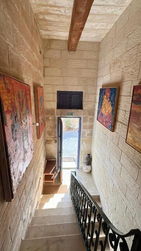a staircase in a house with a stair case and a door at Ta Skorba Farmhouse Mgarr in Mġarr