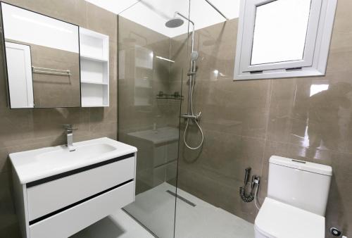 a bathroom with a toilet and a sink and a shower at KAFUL APARTMENTS in Qeparo