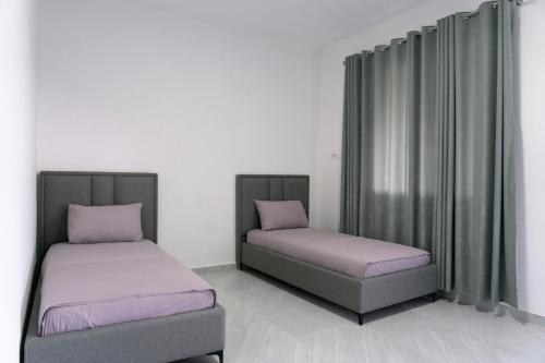 two beds sitting in a room with curtains at KAFUL APARTMENTS in Qeparo