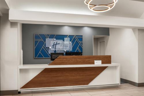 a reception counter in a hospital lobby with wood at Holiday Inn Express Fresno River Park Highway 41 by IHG in Fresno