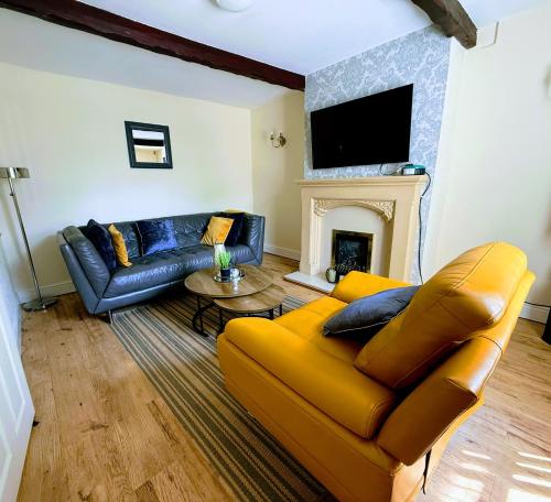 a living room with a yellow couch and a fireplace at 3 BR l Family & Contractors l Parks 3 cars ,near Zoo , NEC in Dudley