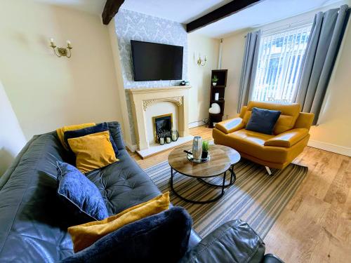 a living room with a couch and a fireplace at 3 BR l Family & Contractors l Parks 3 cars ,near Zoo , NEC in Dudley