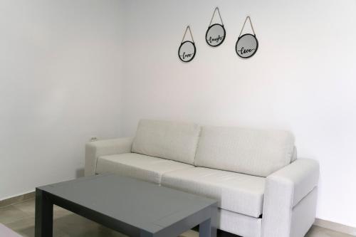 a living room with a white couch and a table at KAFUL APARTMENTS in Qeparo