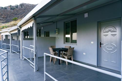 a balcony with a table and chairs on a house at KAFUL APARTMENTS in Qeparo