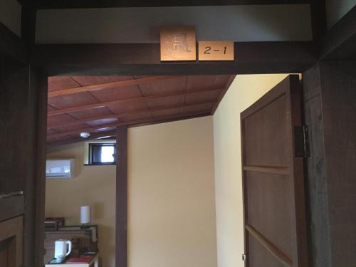 a room with a door and a box on the ceiling at Honmachi Juku in Hikone