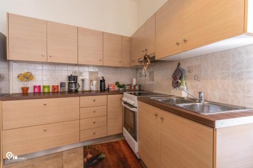 a kitchen with wooden cabinets and a sink at Omiros - Spacious Seaside House At Poros in Poros