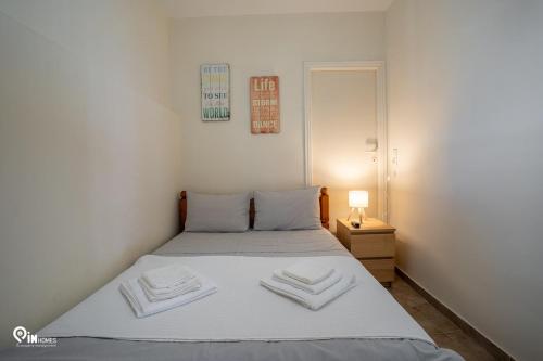 a bedroom with a bed with two towels on it at Omiros - Spacious Seaside House At Poros in Poros