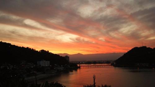 a view of a river with a sunset at Suite no Paraiso! Uma experiência única de paz! in São Vicente