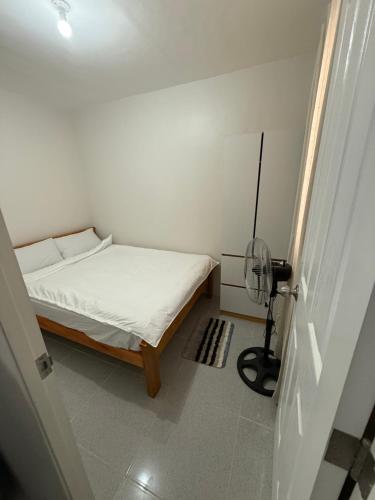a small bedroom with a bed and a fan at JV transient 25 in Ormoc