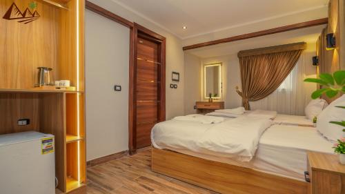 a bedroom with a large bed and a window at Suzana Pyramids hotel in Cairo