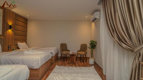 a hotel room with two beds and a table and chairs at Suzana Pyramids hotel in Cairo