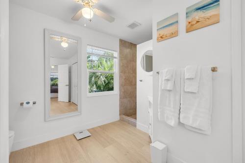 bagno con asciugamani bianchi e specchio di Villa Samba a Cape Coral