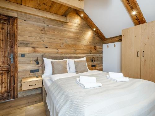 a bedroom with a large bed with wooden walls at Chalet Petra in Katschberghöhe