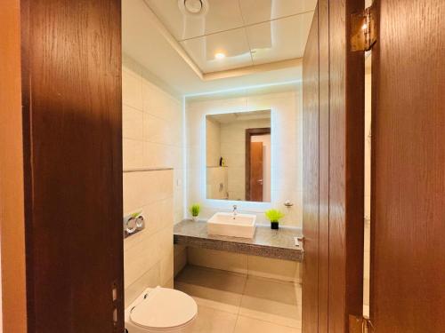 a bathroom with a sink and a toilet and a mirror at 2BHK with Hill and Lake view in Mall of Islamabad Blue Area in Islamabad