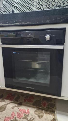 a microwave oven sitting on a shelf in a kitchen at Quartos Privativos ou AP Inteiro 8 minutos do Aeroporto in Salvador