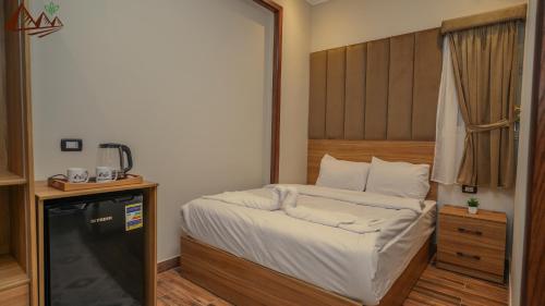 a small bedroom with a bed with a wooden headboard at Suzana Pyramids hotel in Cairo