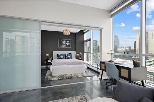 a bedroom with a bed and a desk and windows at Urbanest - Spectacular Views & Amenities Parking in Calgary