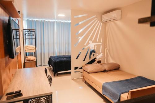 a room with a bedroom with a bed and a tv at LOFT Sofisticado na Praia de Vila - Centro in Saquarema