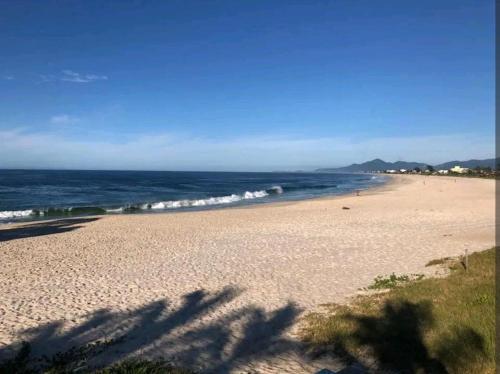 a view of a beach with the ocean in the background at LOFT Sofisticado na Praia de Vila - Centro in Saquarema