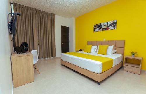 a bedroom with a bed and a television in it at HOTEL CATALUÑA - SOLUCIONES HOTELERAs in Pereira