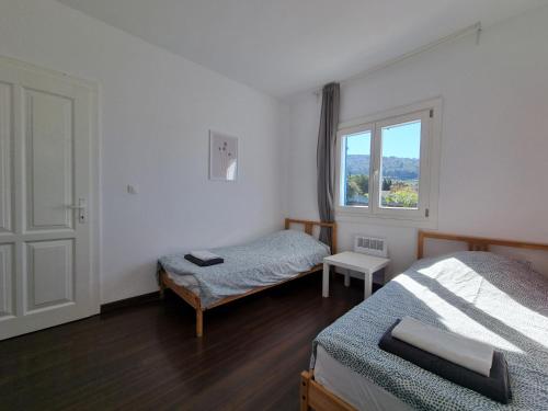 ein Zimmer mit zwei Betten und einem Fenster in der Unterkunft Clos des Oliviers in Oupia