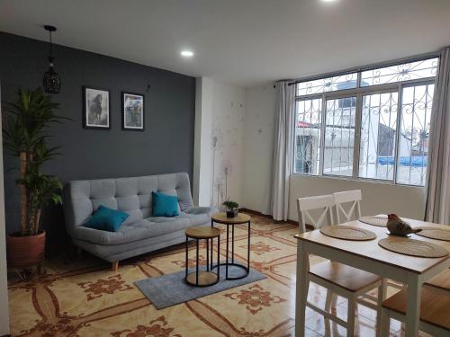 a living room with a couch and a table and chairs at Hostal Ángel Victoria in Yopal