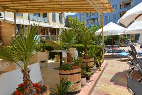 een patio met potplanten en parasols bij Rainbow 1 Holiday Complex in Sunny Beach