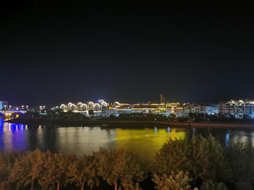 a view of a city at night with a body of water at Seven Love Letters Zen Tea and Flower Bed and Breakfast in Huangshan