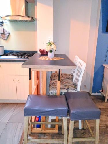 a small table with two blue chairs and a kitchen at Explore New York from Queens in Queens