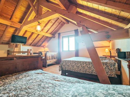a bedroom with two beds in a room with wooden ceilings at Maison de charme en Berry près d'un golf & spa, jardin d'hiver, vélos, animaux bienvenus - tout inclus - FR-1-591-332 in Pouligny-Notre-Dame