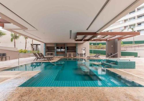 ein Swimmingpool mit blauem Wasser in einem Gebäude in der Unterkunft Grein Solar das Águas Park Resort in Olímpia
