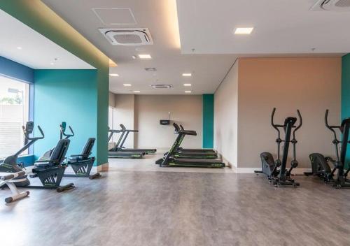 ein Fitnessstudio mit Laufbändern und Crosstrainern in einem Raum in der Unterkunft Grein Solar das Águas Park Resort in Olímpia