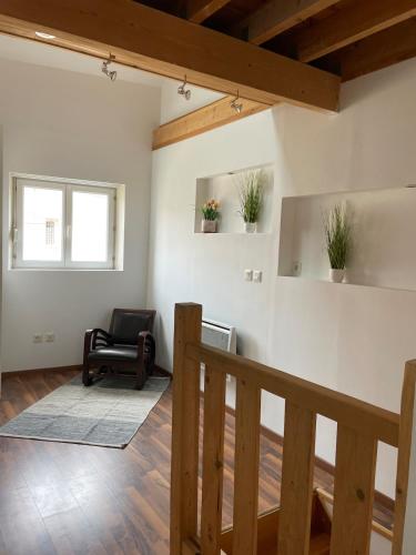 ein Wohnzimmer mit einem Stuhl und einer Treppe in der Unterkunft HSH France Nid de Chambry proche Disneyland in Chambry