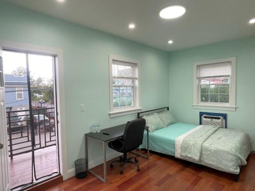a bedroom with a bed and a desk and windows at Near JFK-Private room with share bath and Kitchen in Brooklyn